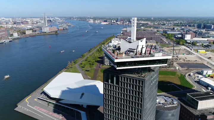 photo of aerial picture of modern building EYE Film Institute located in north Amsterdam also showing IJ lake on left and urban horizon in background the city is a popular tourist destination in Holland the Netherlands.