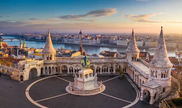Photo of the famous Fisherman's Bastion at sunrise with statue of King Stephen I and Parliament of Hungary at background.