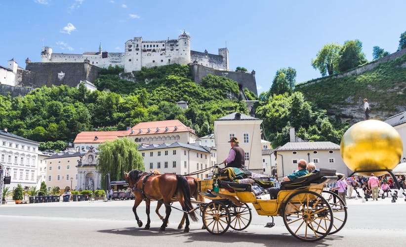 Photo of tourists sightseeing in horse carriage in Salzburg.