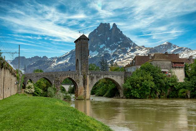 Photo of a bridge over river Gave de Pau in Orthez and Pic du midi Ossau ,France.