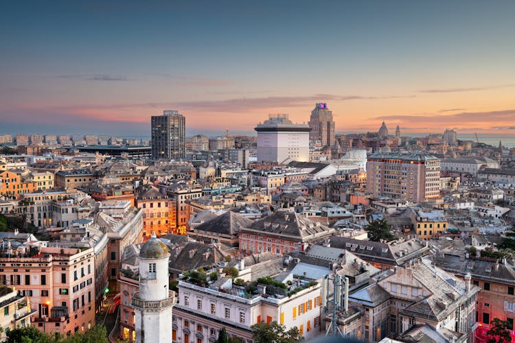 Photo of Genoa, Liguria, Italy downtown city skyline from above at dusk.