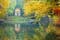 photo of Reflection of a little temple in a pond of the Park of Monza surrounded by yellow autumnal trees, Italy