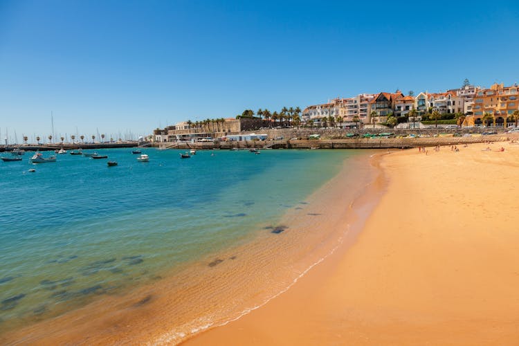 Photo of beach, town and dock of Cascais at summer, Portugal.