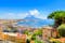 Naples, Italy. View of the Gulf of Naples from the Posillipo hill with Mount Vesuvius far in the background and some pine trees in foreground.