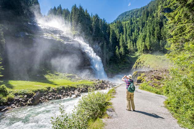 Photo of tourist taking photos of the beautiful Krimml Waterfalls and the surroundings forest in Krimml, Austria.