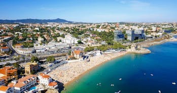 Photo of aerial view over People Crowd Having Fun On Beach And Over Cascais City In Portugal.