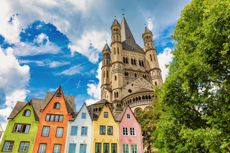 Photo of church Gross St Martin with unique colorful houses in the old town of Cologne, Germany.