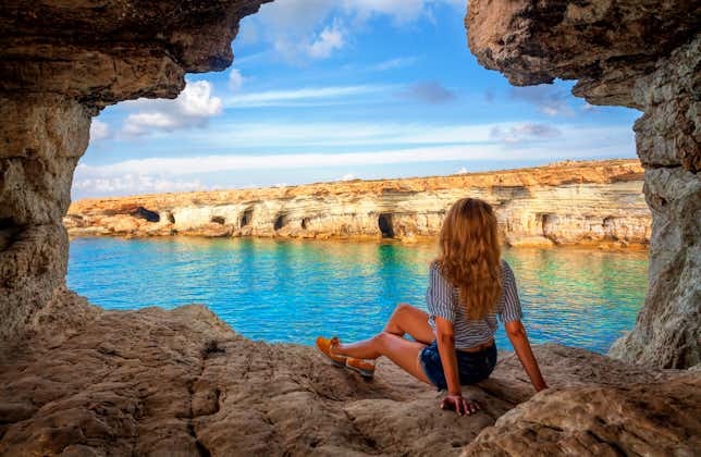 Photo of female tourist Sea cave near Cape Greko(Capo Greco) of Ayia Napa and Protaras on Cyprus island, Mediterranean Sea.