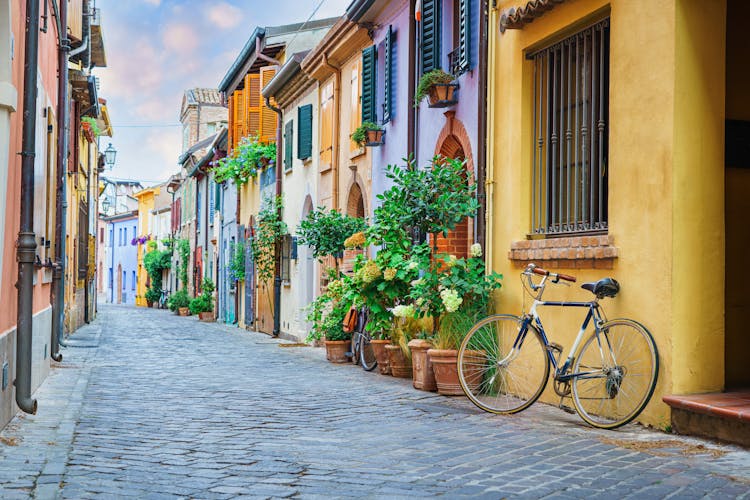 Photo of Narrow street of the village of fishermen San Guiliano with colorful houses and a bicycle in early morning in Rimini, Italy.