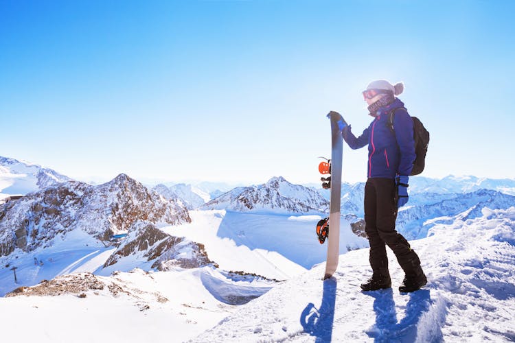 photo of young woman with snowboard, winter holidays in Innsbruck, Austria, panoramic mountain landscape of Alps.
