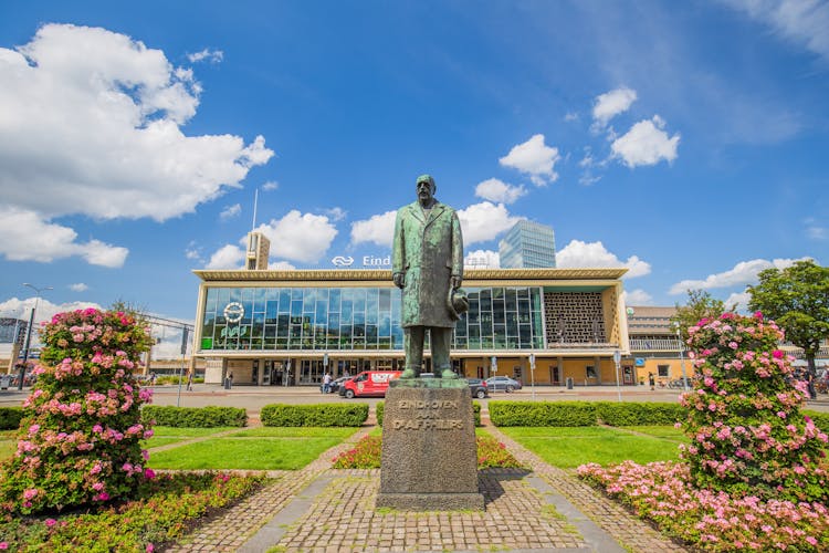 Eindhoven, Netherlands- July 26, 2023: The Central train station of Eindhoven and bus station with in front a statue of Anton Philips. dutch city on a sunny day with blue sky and beautiful clouds.