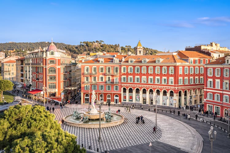 Photo of aerial view of Place Massena square with red buildings and fountain in Nice, France.