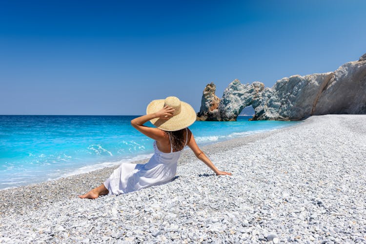 Photo of tourist woman enjoys the turquoise sea of Lalaria beach, Skiathos island, Greece