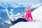 photo of  view of Young girl with her mother in a ski outfit sitting on the snowy hill in the Zillertal Arena, Austria,Radstadt Austria.