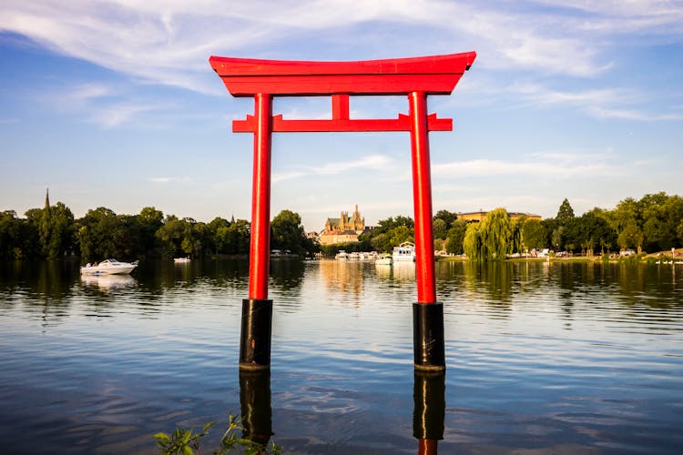 Photo of the Japanese torii in the Plan d'Eau Saint-Symphorien, Saulcy, Metz, France, with the Gothic cathedral of Saint Stephen in the background.