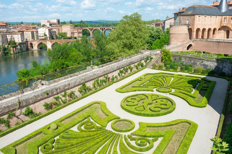 Photo of beautiful view of the Tarn River and a garden with flowers in the Toulouse-Lautrec museum in Albi in France.