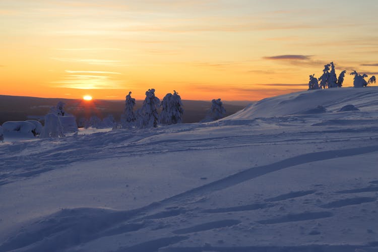 Photo of wintry countryside with sun on horizon in Ylläs in Finnish Lapland, Kolari.