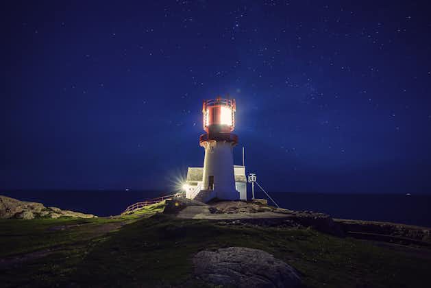 Photo of Lighthouse Lindesnes shines at night on most southern point of Norway.