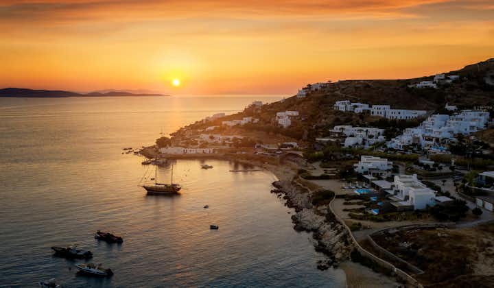 Photo of the beautiful beach and bay of Agios Ioannis Diakoftis  on the island of Mykonos during amazing summer sunset time, Cyclades, Greece.