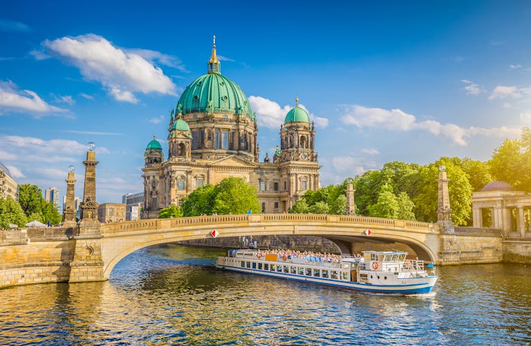 beautiful view of historic Berlin Cathedral (Berliner Dom) at famous Museumsinsel (Museum Island) with excursion boat on Spree river in beautiful sunset in summer, Berlin.