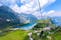 photo of breathtaking view of a serene lake nestled atop Mount Titlis. The lake itself is calm and tranquil, with clear, still waters that reflect the surrounding mountains and sky in Switzerland.