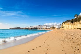 Photo of wide sandy beach in white city of Albufeira, Algarve, Portugal.