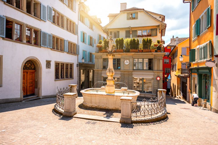 Photo of beautiful small square with fountain in the old town of Zurich city in Switzerland.