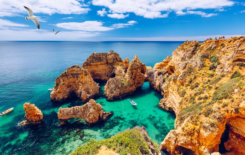 Photo of panoramic view, Ponta da Piedade with seagulls flying over rocks near Lagos in Algarve, Portugal. 