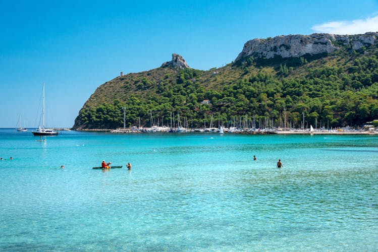 Poetto beach, crystal clear water and the famous Sella del Diavolo, Cagliari, Sardinia, Italy.
