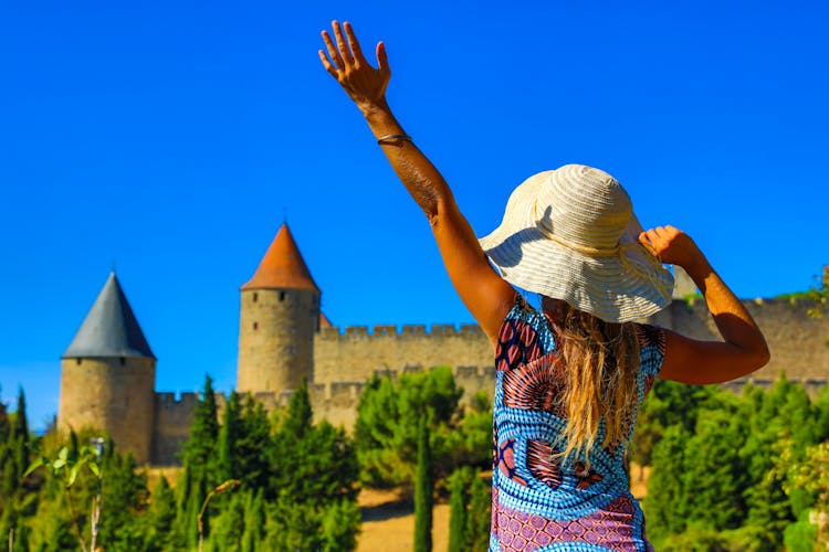 Photo of happy woman visiting Castle of Carcassonne in France.