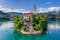 Photo of Bled, Slovenia - Aerial view of beautiful Pilgrimage Church of the Assumption of Maria on a small island at Lake Bled (Blejsko Jezero) and lots of Pletna boats on the lake at summer time with blue sky.