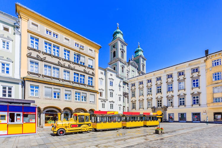 Photo of Linz, Austria. Old Cathedral (Alter Dom) and tourist train in the Main Square.