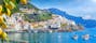 photo of panoramic view of beautiful amalfi on hills leading down to coast, Campania, Italy. Amalfi coast is most popular travel and holiday destination in Europe. Ripe yellow lemons in foreground.