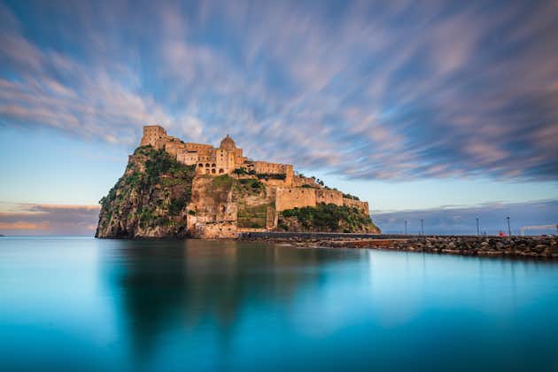 photo of Ischia, Italy with Aragonese Castle in the Mediterranean at dusk.