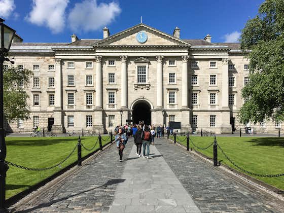 Photo of Regent House at Trinity College under a blue sky in a sunny day. Students access through it to Parliament Square, Book of Kells, and the university buildings.