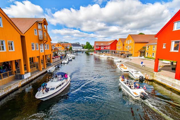 Photo of motorboats navigate on a canal in the Fiskebrygga district in Kristiansand, Norway.