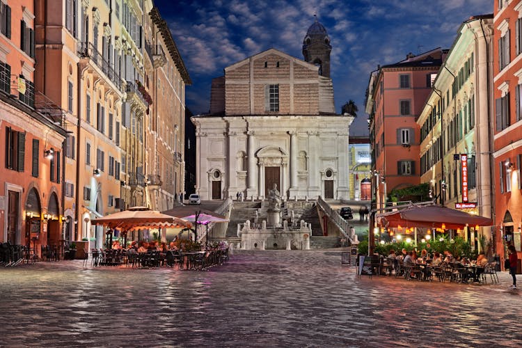 Photo of Plebiscito square in the downtown of the city with the ancient church, the statue of the pope and people in cafe and restaurant.