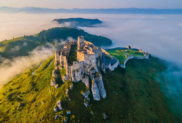 Aerial panoramic view of the Spiš Castle, Slovakia, in the morning sunlight with foggy background and Tatra Mountains seen on the horizon.