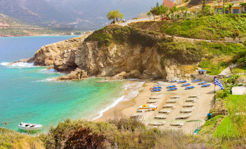 Photo of Sandy Evita and Karavostasi beach in sea bay of resort village Bali, aerial views of shore, washed by waves and sun loungers with parasols where sunbathing tourists, Bali, Rethymno, Crete, Greece.