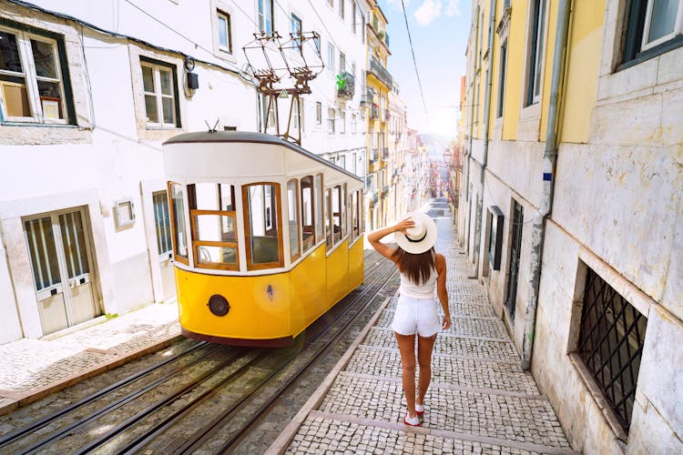 Photo of Woman tourist walking in narrow streets of Lisbon city old town. 