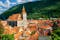 Photo of Brasov cityscape with black cathedral and mountain on backround in Romania .