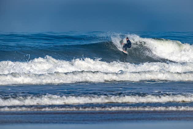 Photo of Surfer riding waves in Furadouro Beach, Portugal. Men catching waves in ocean. Surfing action water board sport. people water sport lessons and beach swimming activity on summer vacation.