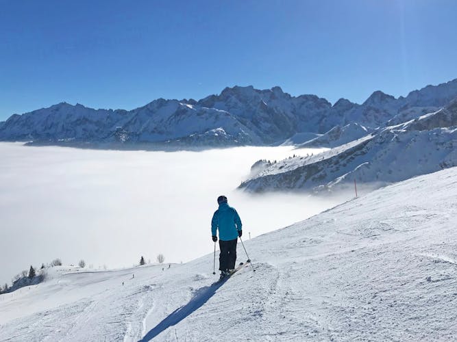 Photo of ski slope in Garmisch Partenkirchen over misty valley.