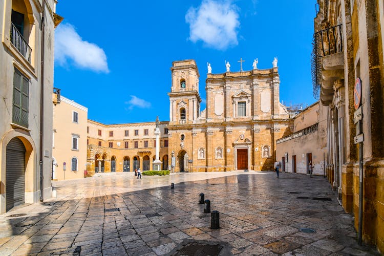 Morning as tourists begin to explore the Brindisi Duomo Cathedral and Bell tower in the Piazza Duomo in Brindisi, Italy, part of the southern Puglia region.