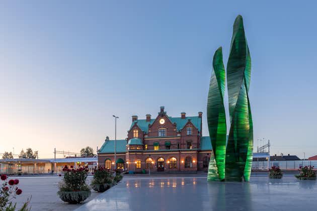  View of the Umea central station building at sunset with the illuminated sculpture green fire.