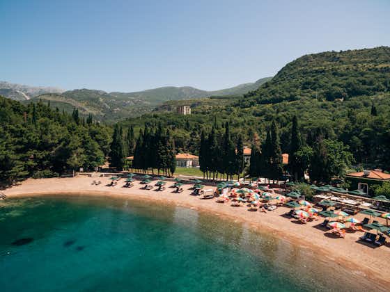Photo of the royal beach of Przno in Montenegro against the backdrop of green slopes.