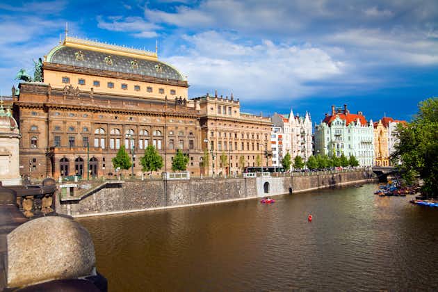 Photo of beautiful view of the Prague National Theater on a bright sunny day along the Vltava River, Czech Republic.