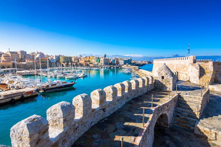 Photo of Heraklion harbour with old venetian fort Koule and shipyards, Crete, Greece.