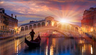 Famous buildings, gondolas and monuments by the Rialto Bridge of Venice on the Grand Canal, Italy.