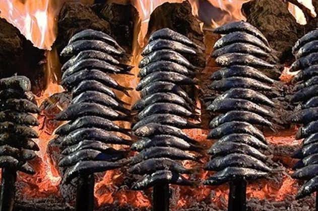 Sardiner på spyd viser madlavning i Malaga strand